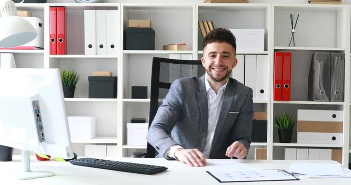 Director siting in white office, smiling and conducting interview