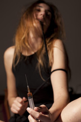 Obraz premium drug addicted girl with a syringe using drugs