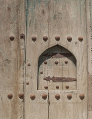 Old wooden door with metal rivets in Bukhara, Central Asia.