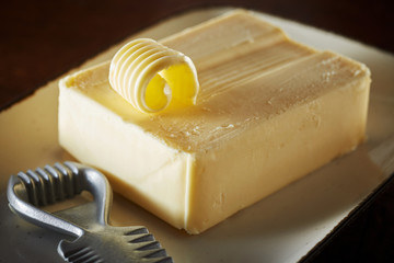 Pat of farm fresh butter with metal curler - obrazy, fototapety, plakaty