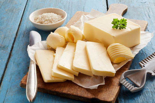 Block of fresh butter on wooden cutting board