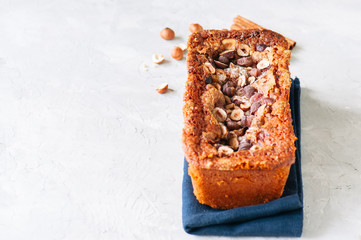Pumpkin espresso bread with hazelnuts on a blue napkin on a white stone background. Top view and copy space.