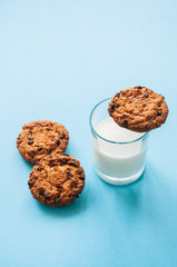 Cookies with a glass of milk on a light blue background.