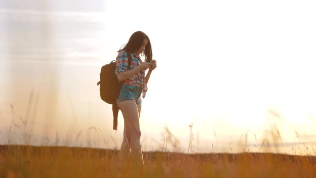 Hipster hiker silhouette girl is shooting video of beautiful nature sundown on cell telephone smartphone slow motion video. Female tourist is taking photo with mobile phone camera lifestyle. female