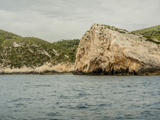 Rocks over Blue cave entrance at island Vis in Croatia. Shot from sailing boat.
