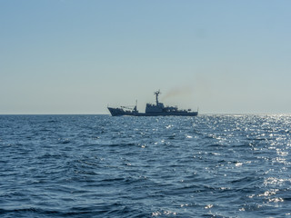 Croatian military battleship cruising arround at evening sunset.