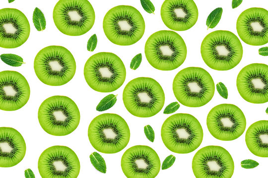 Creative layout made of Kiwi fruits snd mint leaves. Many slices of ripe and juicy Kiwifruit. Flat lay.