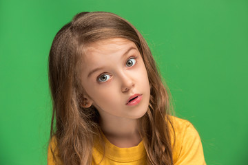 Fototapeta premium Beautiful teen girl looking suprised isolated on green