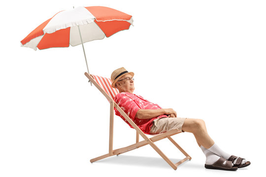 Elderly tourist sitting on a deck chair with an umbrella