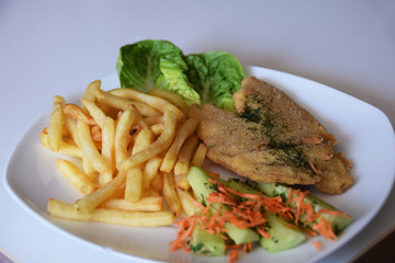 fries and a salad of fresh cucumber and grated carrot fried fish
