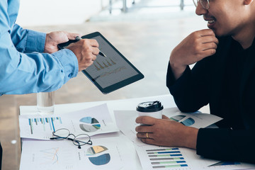 Asian businessmen convened for a meeting with  digital graphs and charts describing their work.