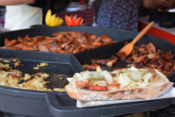 bread sandwich with lard and slices of sausages baked in a stone pot at a picnic