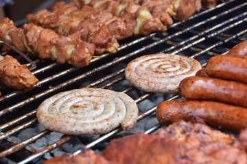 wrapped white sausage on the grill in the company of other sausages
