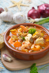 Mediterrane Fischsuppe mit frischem Weißbrot serviert – Mediterranean bouillabaisse ( French...