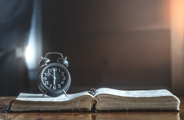Clock on holy Bible in the morning, How much the time of man given to God,christian concept.