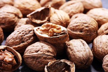 Walnut kernels and whole walnuts on rustic old table