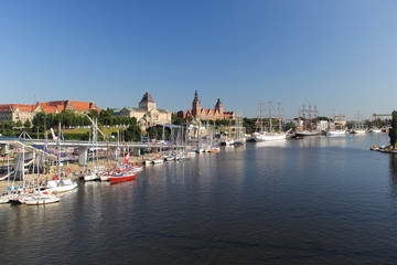 City view of town Szczecin, west Poland, with river banks and tall sail ships on the port. - obrazy, fototapety, plakaty