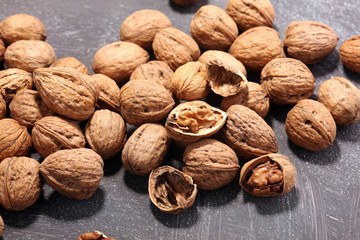 Walnut kernels and whole walnuts on rustic old table