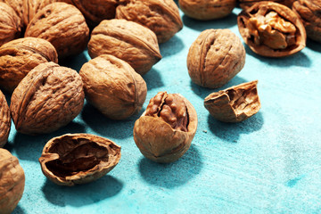 Walnut kernels and whole walnuts on rustic old table