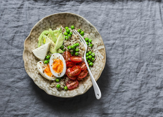 Quinoa, vegetables, egg, tofu buddha bowl on grey background, top view. Healthy diet food concept. Copy space