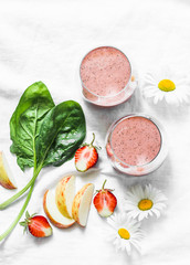Coconut probiotic yogurt, spinach, apple, strawberry detox smoothie on a light background, top view. Healthy diet food concept.  Flat lay