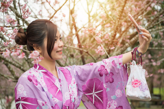 young lady standing under the cherry blossom