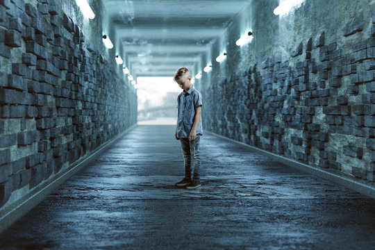 Trauriges Kind in einem Tunnel