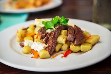 Sirloin stripes, gnocchi, cheese and vegetable.