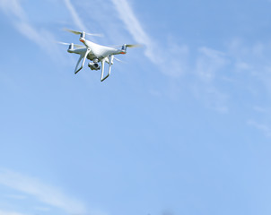 Drone with camera flying on a clear sunny sky background