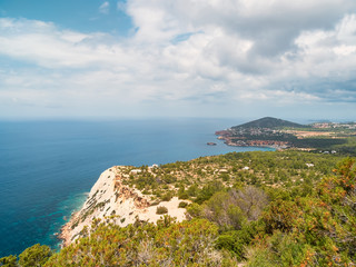 Acantilados, mar mediterraneo turquesa y montañas, del parque natural de Cala D´hort, en Ibiza, España. Es una ruta de trekking que lleva hasta la Torre des savinar para poder contemplar Es Vedrá.