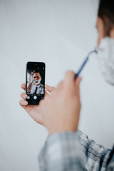 Handsome man shaving his beard in office