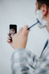 Handsome man shaving his beard in office
