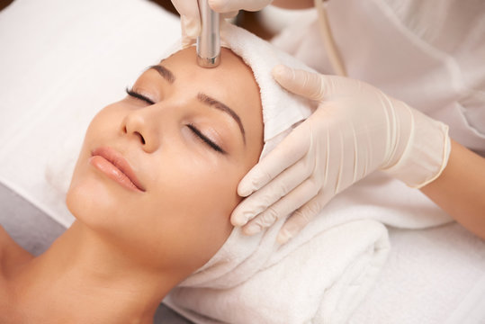 Young relaxed female having anti-wrinkle beauty procedure on face