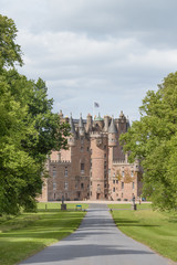 View of Glamis Castle from the driveway in Angus, Scotland, United Kingdom. The Castle is situated close to the village of Glamis and is the home of the Earl of Strathmore and Kinghorne.