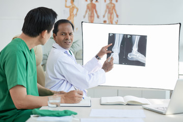 Two doctors looking at x-ray scan at doctor's office
