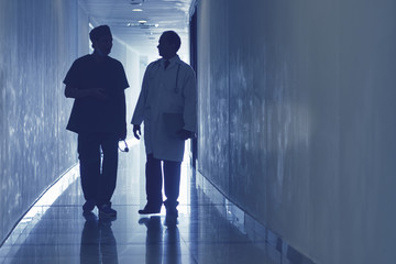 Two doctors walking along the corridor and communicating