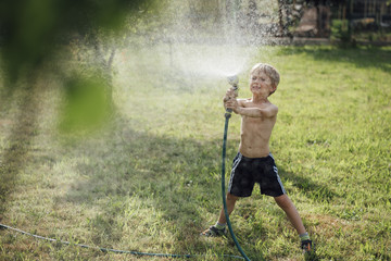 5-6 year old boy watering garden