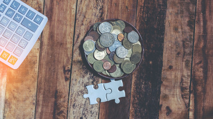 Step of coins stacks and puzzle pieces on wooden boards,