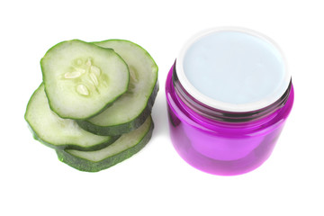 Face cream in lilac jar with cucumber extract with fresh cucumber on white background. isolated