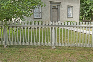 Old white ornate wooden fence around the house