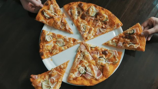 Fresh pizza with meat beaf chicken pork, tomatoes, vegetables, mushrooms. closeup. Process, stages of cooking pizza. juicy, mouth-watering pizza is cut with a metal pizza cutter on wooden background