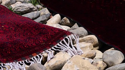 A medium shot of a red carpet laid down on stones.