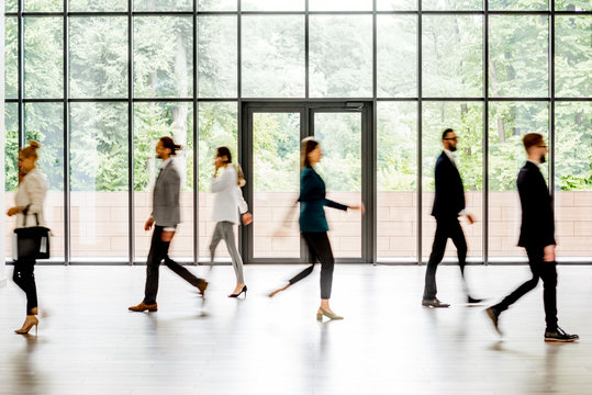 Business people walking at the modern hall on the window background indoors. long exposure image technic with motion blurred people