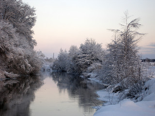 Winter landscape with a river, trees, snow.