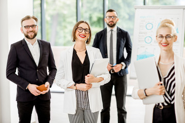 Portrait of a group of business people standing during a conference with flip chart at the modern office