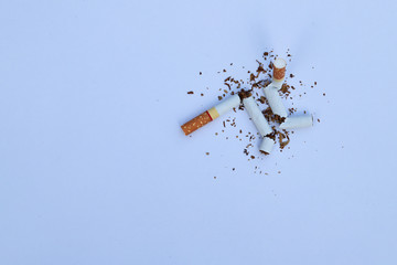 Cutting cigarettes on white paper background, symbol of stop smoking campaign.