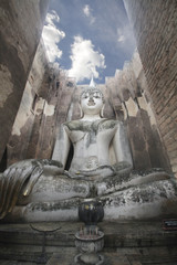 Ancient marvellous stone buddha statue surrounding by great wall and attractive blue sky at Wat Sri Chum, Sukhothai, Thailand, smilling peace buddism location , travel destination backgrounds,