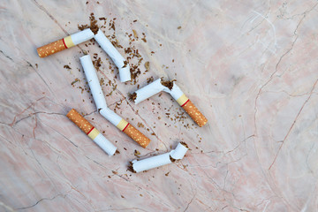 Cutting cigarettes on marble table,  symbol of stop smoking campaign.