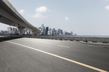 asphalt road with city skyline