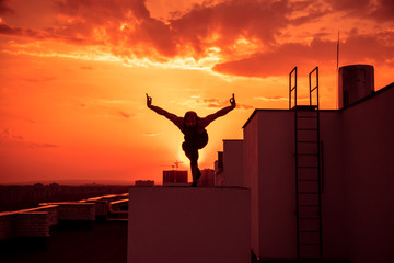  A middle-aged man is engaged in yoga on the roof.